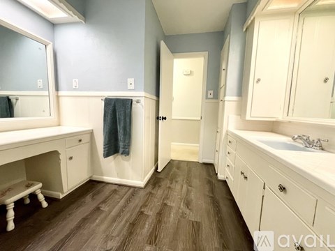 A bathroom with a white vanity and a white sink.