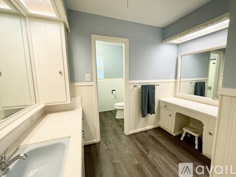 A bathroom with a sink, mirror, and toilet.