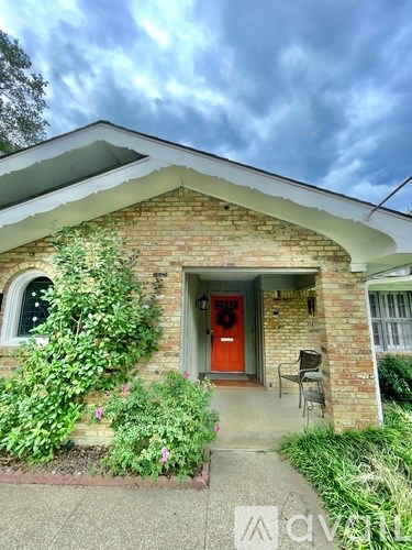 A house with a red door and a brick wall.