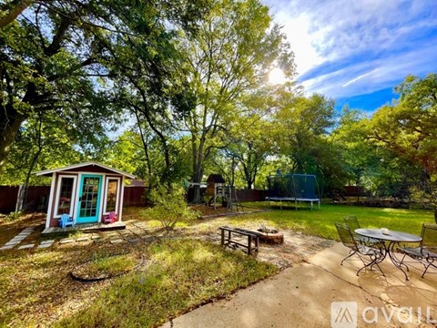 A backyard with a gazebo, picnic table, and play structure.