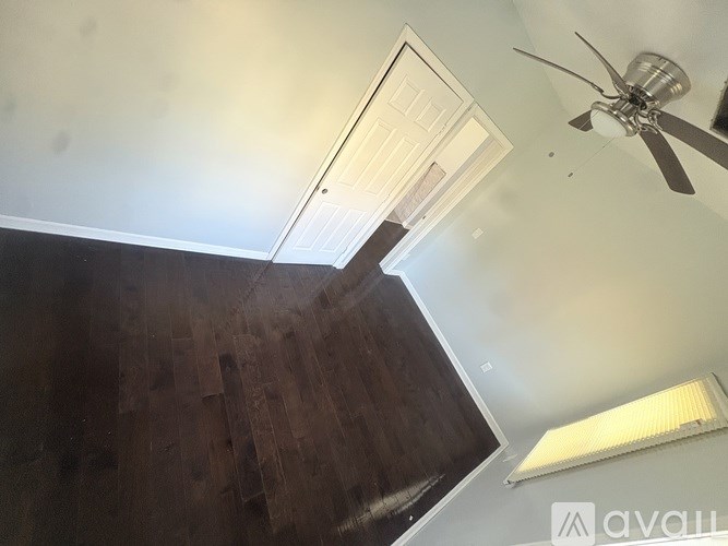 A room with two windows and wooden flooring.