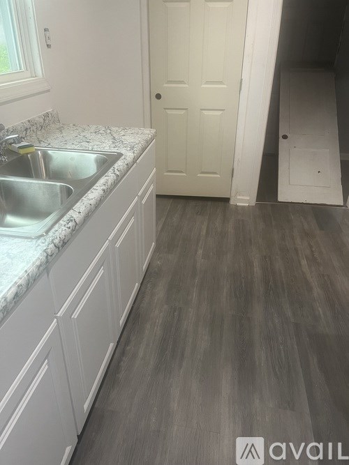 A kitchen with a sink and a door.