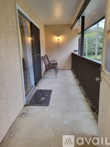 A patio with a chair and a mat.