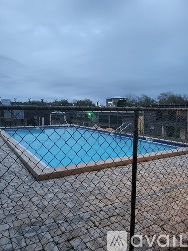 A pool surrounded by a black fence with the word "avail" written on it.