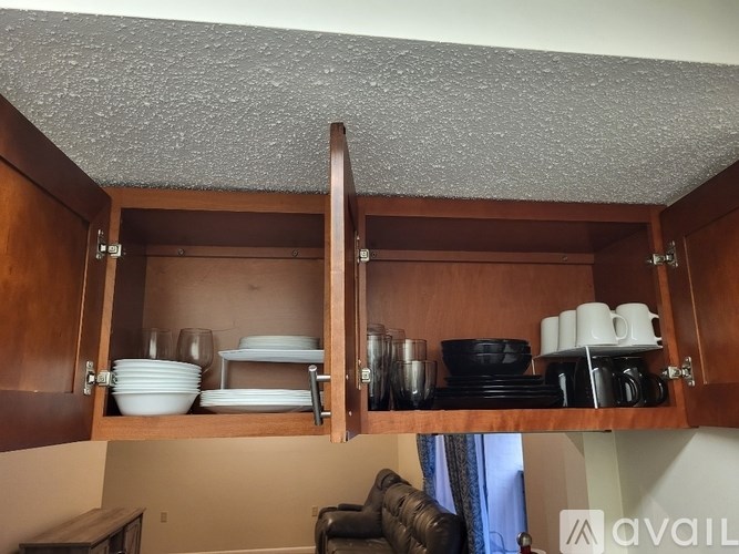 A kitchen cabinet with plates and glasses on it.