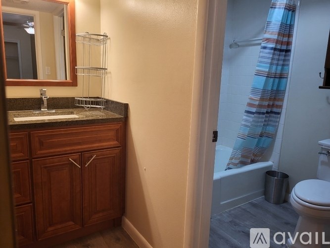 A bathroom with a toilet, sink, and a mirror.