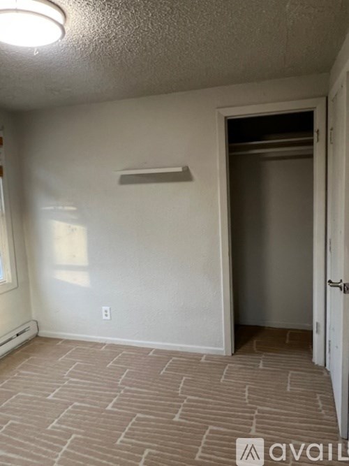 A room with a carpeted floor and a door leading to another room.