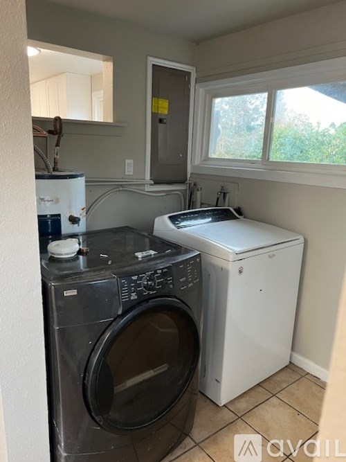 A small laundry room with a washer and dryer.