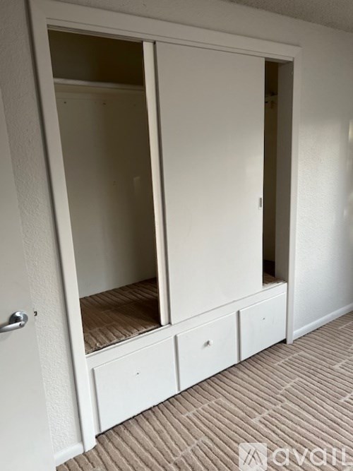 A white wardrobe with two doors and two drawers is open.