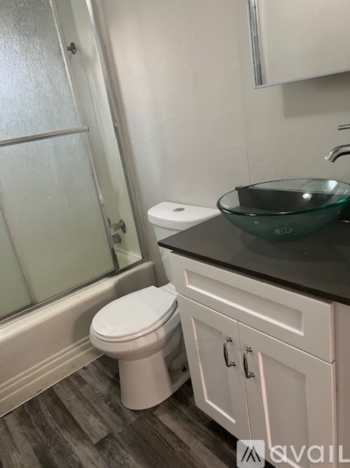A bathroom with a toilet, sink, and shower.