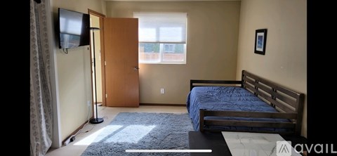 A bedroom with a bed, dresser, and window.