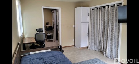 A bedroom with a bed, desk, and chair.