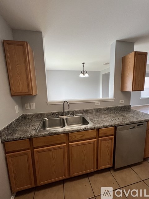 A kitchen with wooden cabinets and granite countertops.