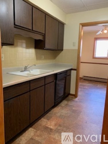 A kitchen with brown cabinets and a white sink.