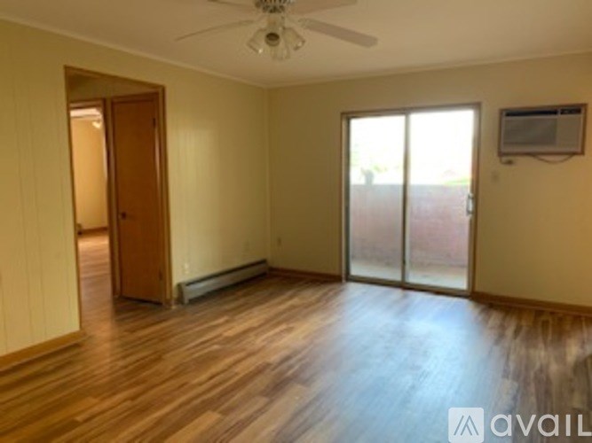 A room with wooden floors and a ceiling fan.