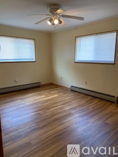 A room with wooden floors and a ceiling fan.
