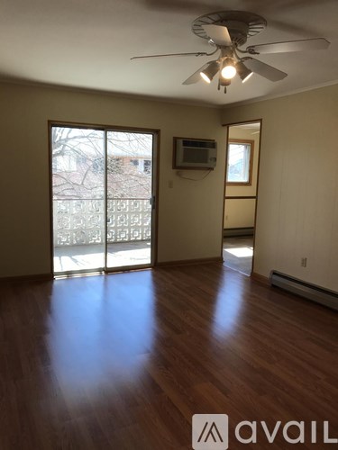 A room with a ceiling fan and sliding glass doors.