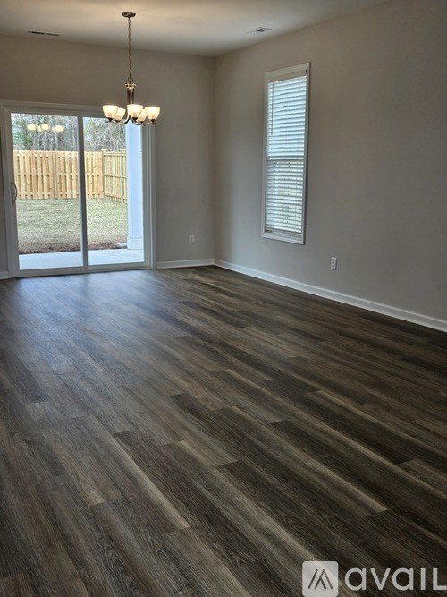 A room with wooden flooring and a chandelier.