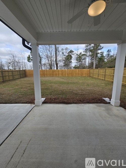 A covered porch area with a white ceiling and a concrete floor.