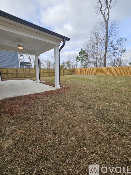 A covered patio area with a wooden fence in the background.