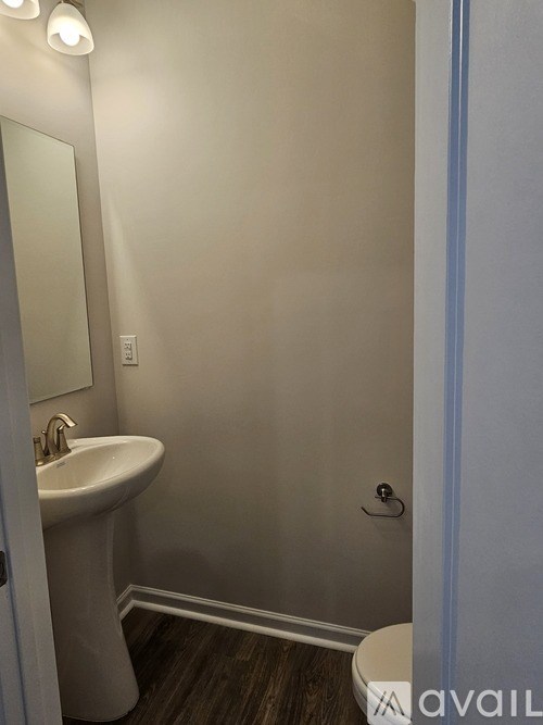 A bathroom with a sink, toilet and mirror.