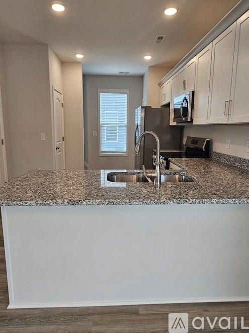 A kitchen with granite countertops and white cabinets.