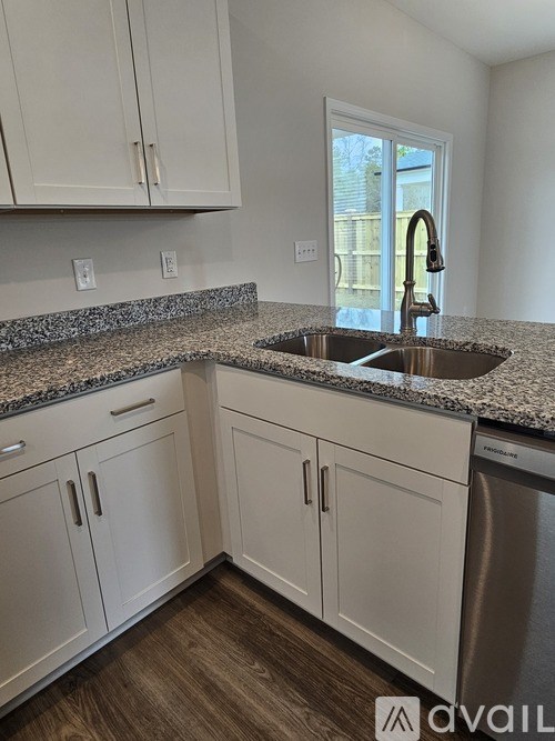 A kitchen with granite countertops and white cabinets.