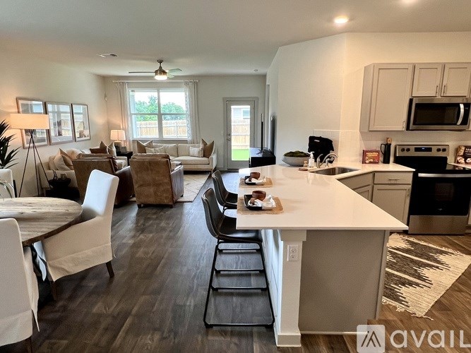 A kitchen with a white island and black countertops.