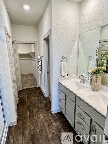 A bathroom with a wooden floor and white walls.