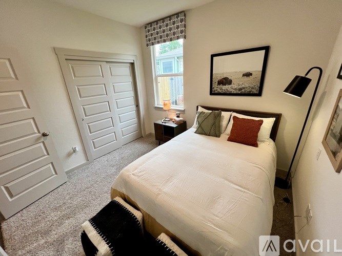 A bedroom with a large bed and a painting on the wall.