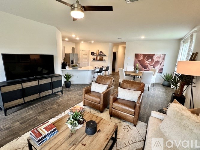 A living room with a wooden floor and a ceiling fan.