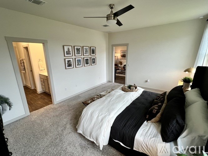 A bedroom with a large bed and a ceiling fan.