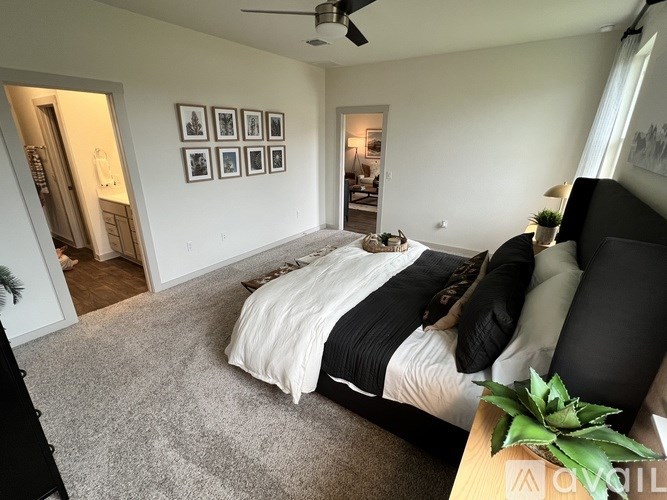 A bedroom with a bed, pillows, and a ceiling fan.