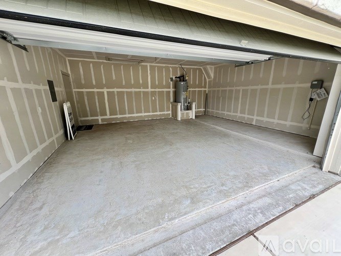 A spacious garage with a concrete floor and a concrete wall.