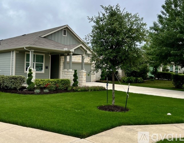 A house with a grey roof and a green lawn.