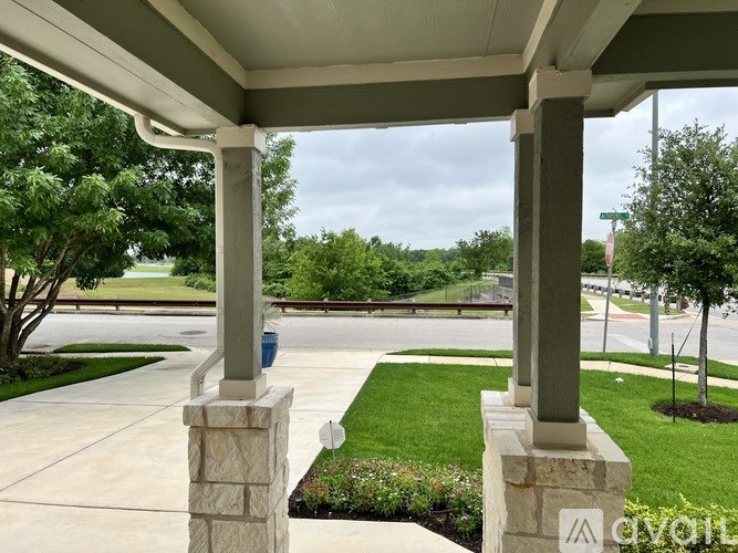 A porch with a view of a street and trees.