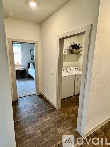 A room with a wooden floor and a white door leading to another room.