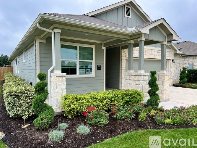 A house with a grey exterior and a landscaped front yard.