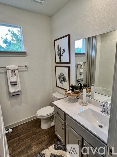 A bathroom with a toilet, sink, and mirror.