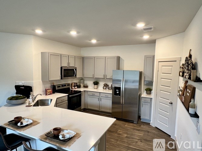 A kitchen with a white countertop and stainless steel appliances.