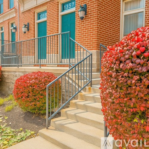 A red bush is in front of a building with a green door.