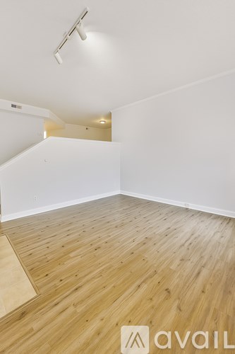A room with wooden flooring and white walls.