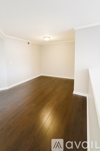 A room with wooden flooring and white walls.