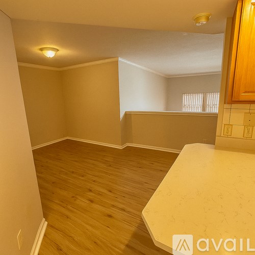 A room with wooden flooring and a kitchen counter.