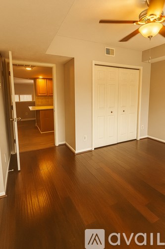 A room with a ceiling fan and wooden floors.