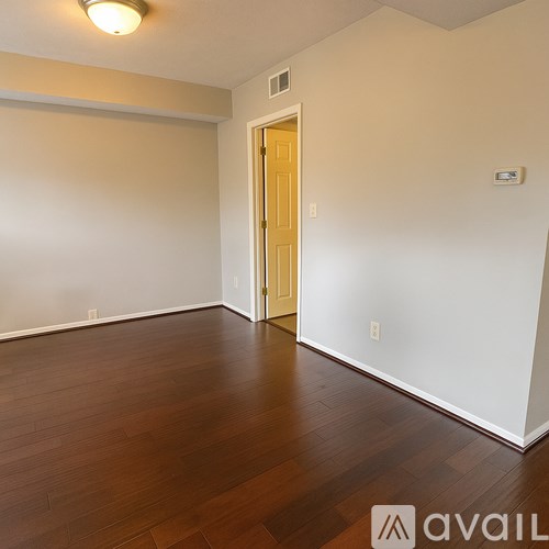A room with wooden flooring and a white door.