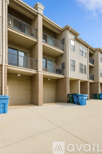 Apartment building with blue bins in front.