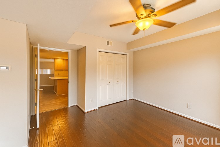 A room with a ceiling fan and wooden floors.