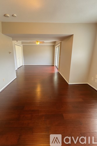 A long hallway with wood floors and white walls.