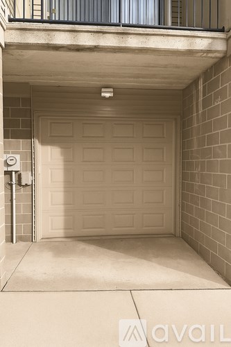 A garage door is closed and there is a wall on the right side.